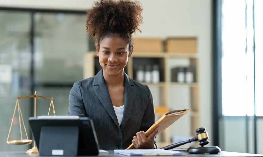 Successful african american woman lawyer or legal advisor working at a desk and holding an envelope